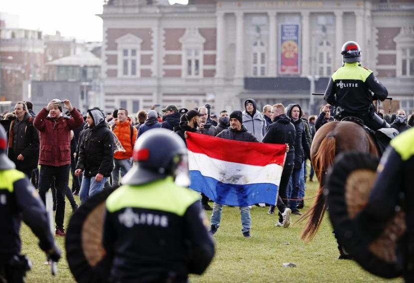 Pengunjuk rasa berkumpul di Museumplein town square pada Ahad (17/1) memprotes kebijakan karantina nasional.