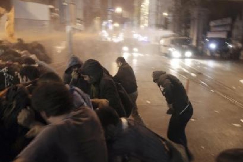 Pengunjuk rasa lari dari semburan air yang disemprotkan polisi untuk membubarkan unjuk rasa pro-Kurdi di Istanbul.