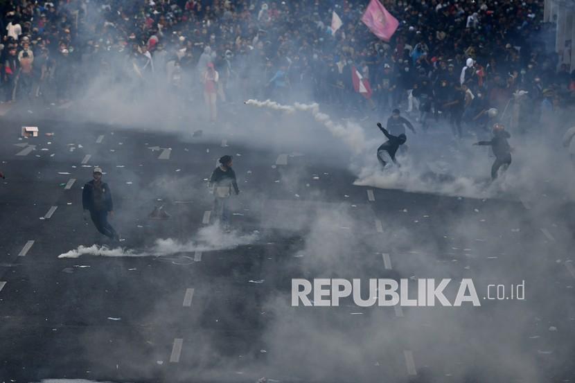 Pengunjuk rasa melempar batu ke arah polisi saat demo menolak Undang-undang Cipta Kerja di depan Gedung Negara Grahadi, Surabaya, Jawa Timur, Kamis (8/10/2020). Aksi yang dikuti ribuan orang dari berbagai elemen mahasiswa dan buruh tersebut berakhir ricuh dan mengakibatkan sejumlah fasilitas umum rusak.