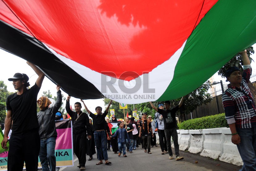  Pengunjuk rasa membawa bendera Palestina raksasa saat unjuk rasa beberapa organisasi muslim di depan Kedubes Amerika Serikat (AS), Jakarta, Jumat (25/7).  (Republika/Aditya Pradana Putra)