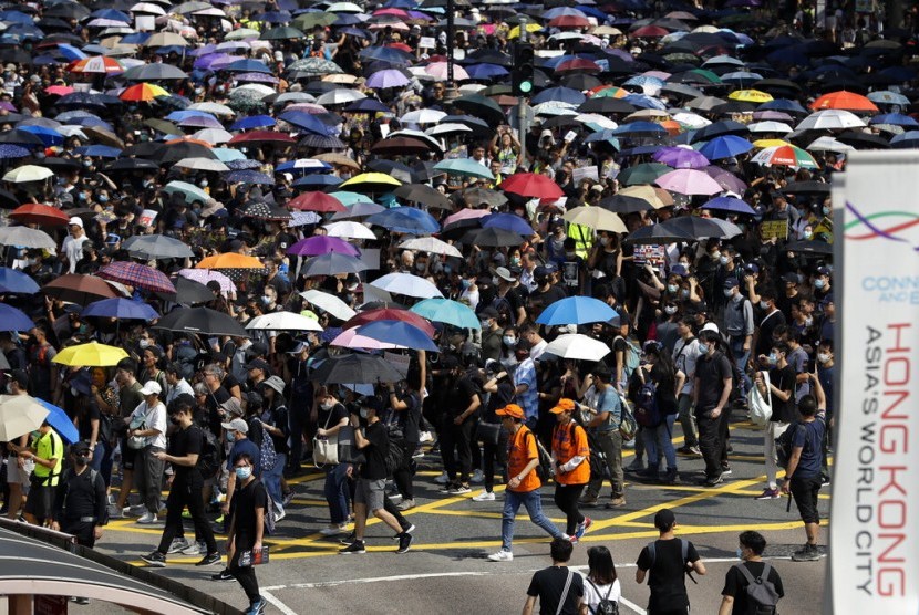 Pengunjuk rasa membawa payung dalam demonstrasi di Hong Kong, Ahad (20/10).