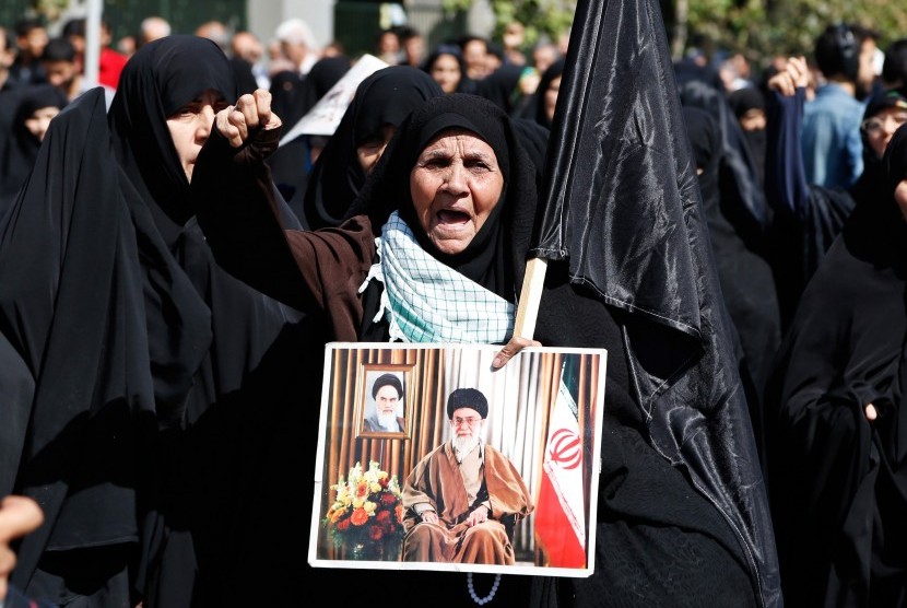 Pengunjuk rasa memegang gambar pemimpin tertinggi Iran, Ayatollah Ali Khamenei, selama protes mengutuk Arab Saudi atas kematian jamaah haji (Ilustrasi)