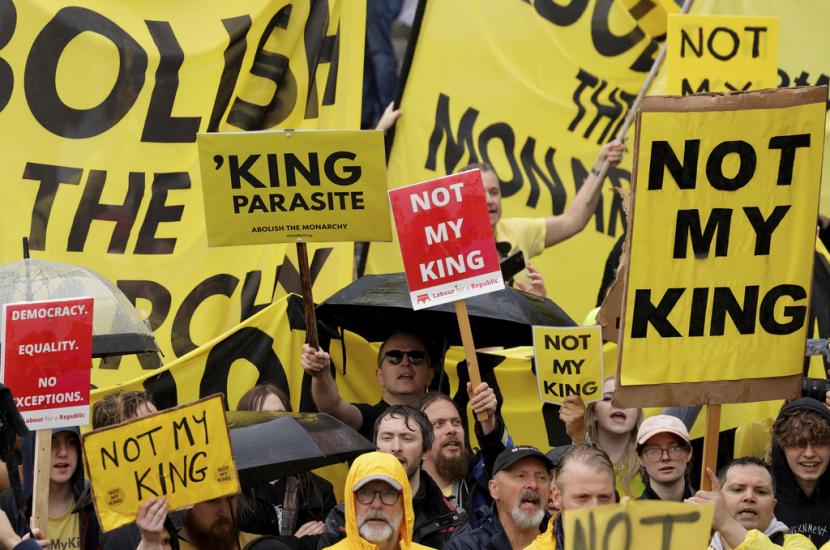 Pengunjuk rasa memegang plakat saat orang berkumpul untuk penobatan Raja Inggris Charles III di Westminster Abbey di pusat kota London, Sabtu, 6 Mei 2023.