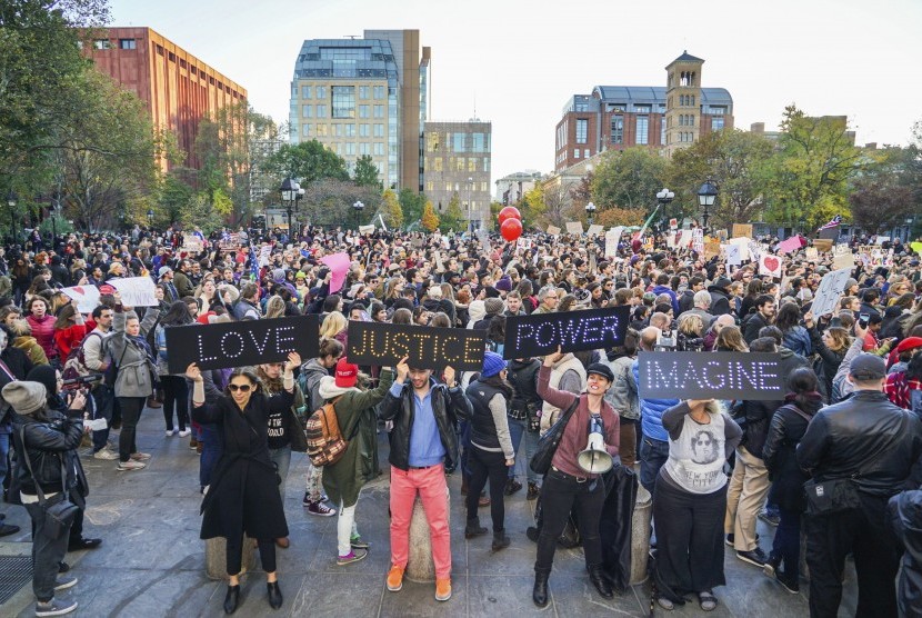 Pengunjuk rasa memegang poster besar dalam aksi 'Love Rally' menentang terpilihnya Donald Trump sebagai presiden. Massa beraksi di Washington Square Park menuju Union Square di New York, (11/111).