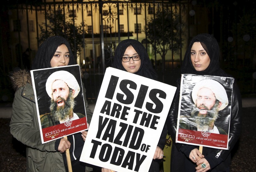Pengunjuk rasa memegang poster memprotes eksekusi ulama Syiah di depan Kedutaan Arab Saudi di London, Sabtu (2/1).