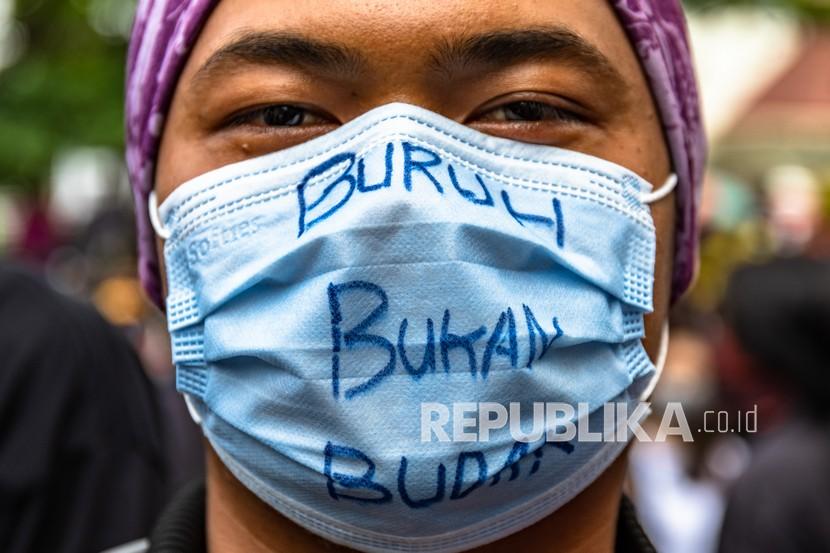 Pengunjuk rasa mengenakan masker saat demonstrasi menolak UU Cipta Kerja (foto ilustrasi).