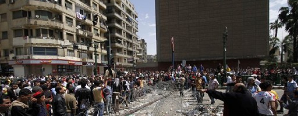 Pengunjuk rasa menyingkirkan kawat berduri yang memblokade Tahrir Square, Senin (11/4).