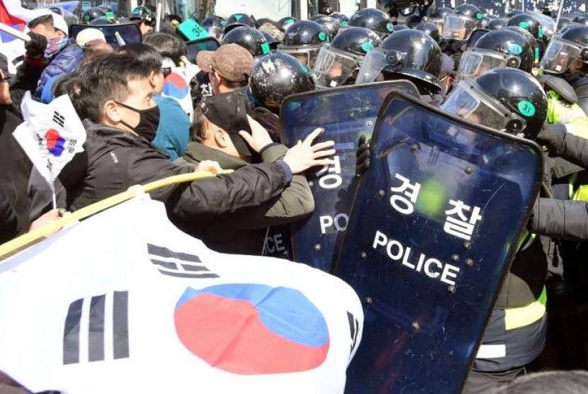 Pengunjuk rasa pendukung Presiden Korea Selatan Park Geun-hye bentrok dengan polisi dekat Mahkamah Konstitusi di Seoul, Korea Selatan.