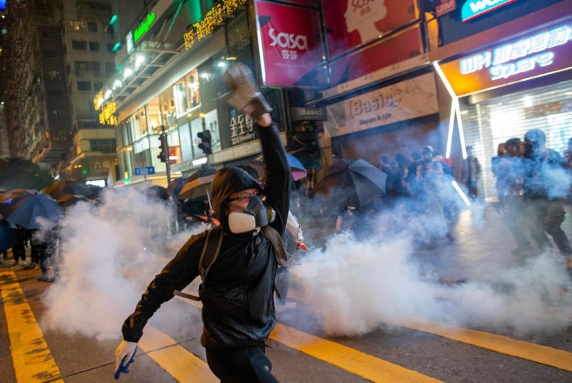 Pengunjuk rasa pro demokrasi saat bentrok menghadapi polisi anti huru-hara di kawasan bisni Tsim Sha Tsui, Hong Kong, di Hong Kong, Selasa (24/12)
