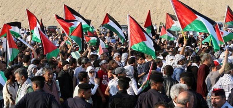 Pengunjuk rasa pro-Palestina di Yordania mengibarkan bendera ketika mendekati perbatasan Yordania-Israel, Ahad (15/5).