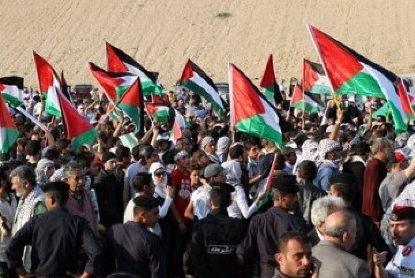 Pengunjuk rasa pro-Palestina di Yordania mengibarkan bendera ketika mendekati perbatasan Yordania-Israel, Ahad (15/5).