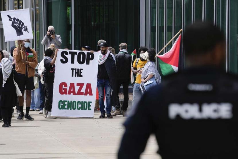 Pengunjuk rasa pro-Palestina membentangan tulisan agar menghentikan genosida di Gaza.