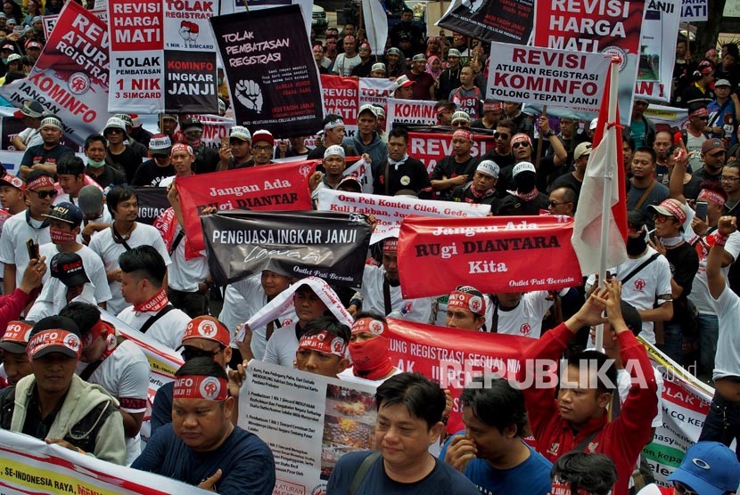 Pengunjuk rasa yang tergabung dalam Kesatuan Niaga Celluler Indonesia (KNCI) membentangkan spanduk dan poster, saat berunjuk rasa menolak pembatasan registrasi kartu prabayar telepon seluler satu NIK untuk tiga kartu.