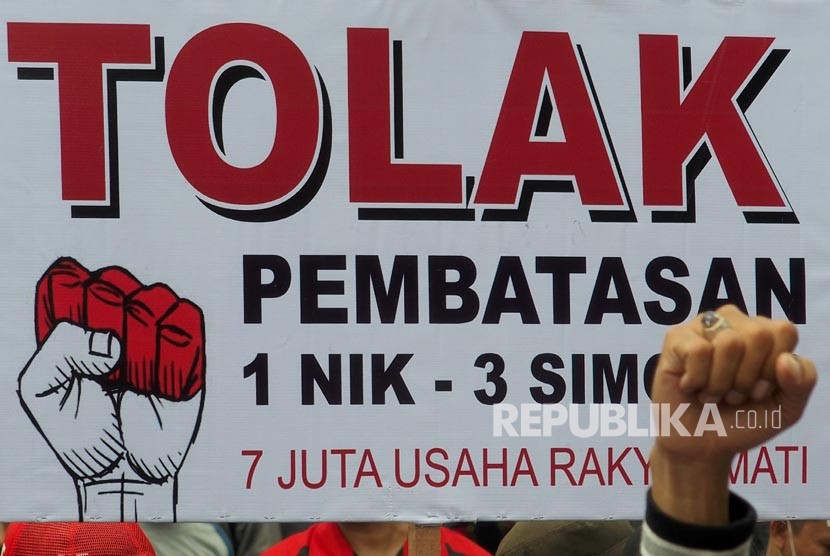 Pengunjuk rasa yang tergabung dalam Kesatuan Niaga Celluler Indonesia (KNCI) membentangkan spanduk dan poster, saat berunjuk rasa menolak pembatasan registrasi kartu prabayar telepon seluler satu NIK untuk tiga kartu.