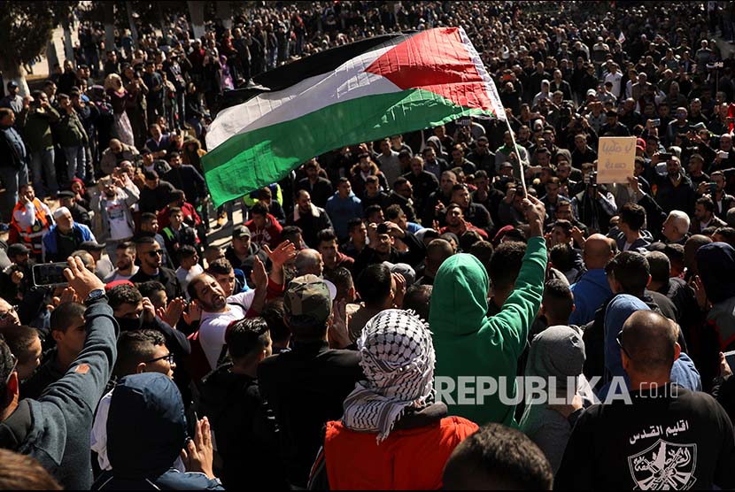 Pengunjukrasa mengibarkan bendera Palestina di Kompleks Al Aqsa, Yerusalem, Palestina, Jumat (8/12)