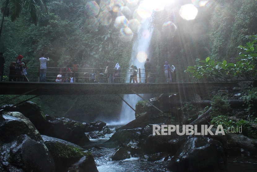 Pengunjung beraktivitas di dekat air terjun, kawasan Taman Nasional Gunung Gede dan Pangrango, di Sukabumi, Jawa Barat, Senin (18/6).