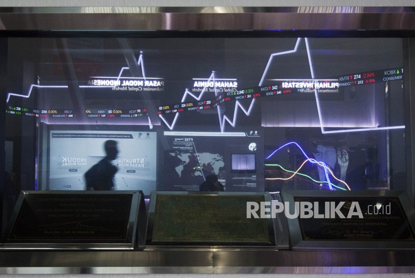 Pengunjung beraktivitas di dekat layar monitor pergerakan saham di gedung Bursa Efek Indonesia, Jakarta, Kamis (20/12/2018).