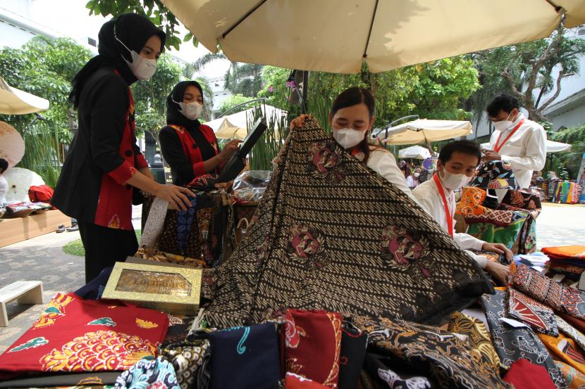 Pengunjung berbelanja kain batik saat pembukaan pameran dan bazar UMKM bertajuk Canthing Jawi Wetan Go Global (CJWGG) di Kantor Gubernur Jawa Timur di Surabaya, Jawa Timur, Sabtu (26/3/2022). CJWGG yang digelar hingga 28 Maret 2022 tersebut untuk mempromosikan kekayaan batik Jawa Timur sehingga dapat membantu percepatan pemulihan ekonomi yang terdampak pandemi COVID-19.