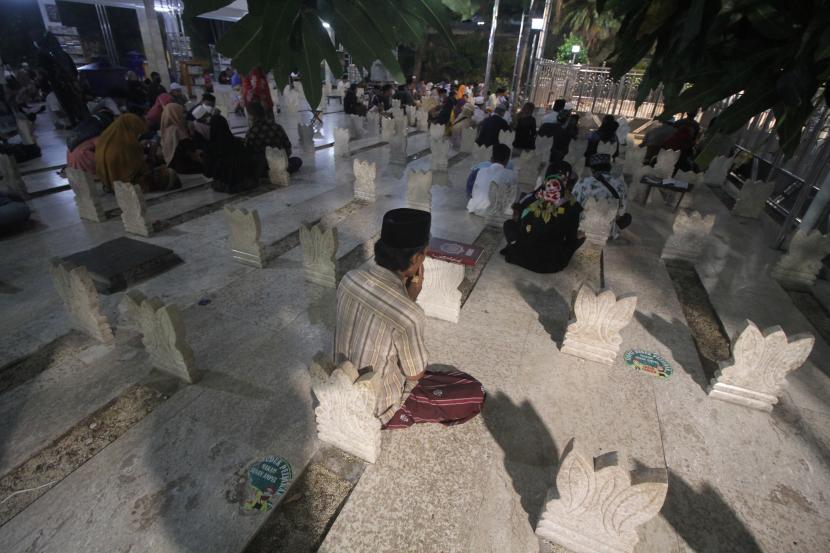 Pengunjung berdoa saat malam 27 Ramadhan 1442 H di kompleks makam Sunan Ampel, Surabaya, Jawa Timur, Sabtu (8/5/2021). Kompleks wisata religi masjid dan makam Sunan Ampel tersebut merupakan salah satu tempat yang dikunjungi warga untuk ibadah mengharapkan Lailatul Qadar atau malam kemuliaan. 