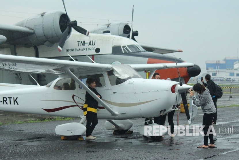 Pengunjung berfoto dengan latar pesawat yang dipamerkan pada acara Bandung Air Show 2017 di kawasan Lanud Husein Sastranegara, Kota Bandung, Kamis (9/11). 