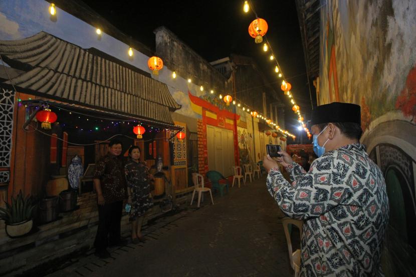 Pengunjung berfoto di depan salah satu mural bernuansa Tionghoa saat peluncuran awal Wisata Kampung Pecinan di Jalan Kapasan Dalam, Surabaya, Jawa Timur. Walkot Surabaya Eri Cahyadi ingin bangunan kuno dikategorikan secara tematik.