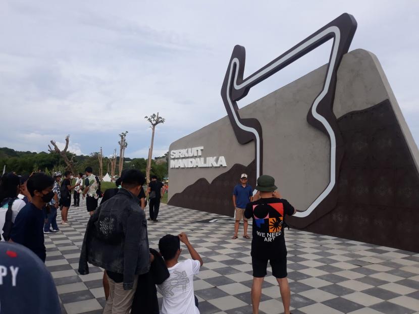 Pengunjung berfoto di Landmark Sirkuit Mandalika, Jumat (18/3/2022). Aparat gabungan mulai melakukan penyekatan jalan menuju Sirkuit Mandalika.