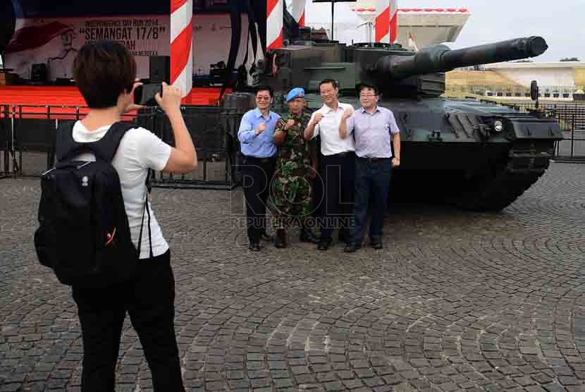 Pengunjung berfoto didekat tank Leopard yang dipajang disamping panggung di Tugu Monas, Jakarta, Jumat (29/8). (Republika/Agung Supriyanto)