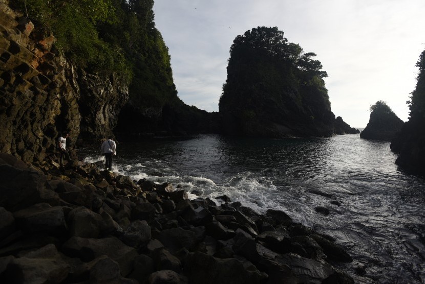 Pengunjung berjalan di antara bebatuan yang bersusun di kawasan Goa Sarang, Sabang, Pulau Weh, Aceh.  (Antara/Zabur Karuru)