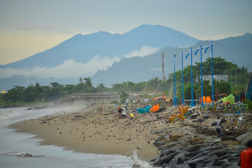Pengunjung berjalan di antara sampah yang berserakan di Pantai Padang, Sumatera Barat