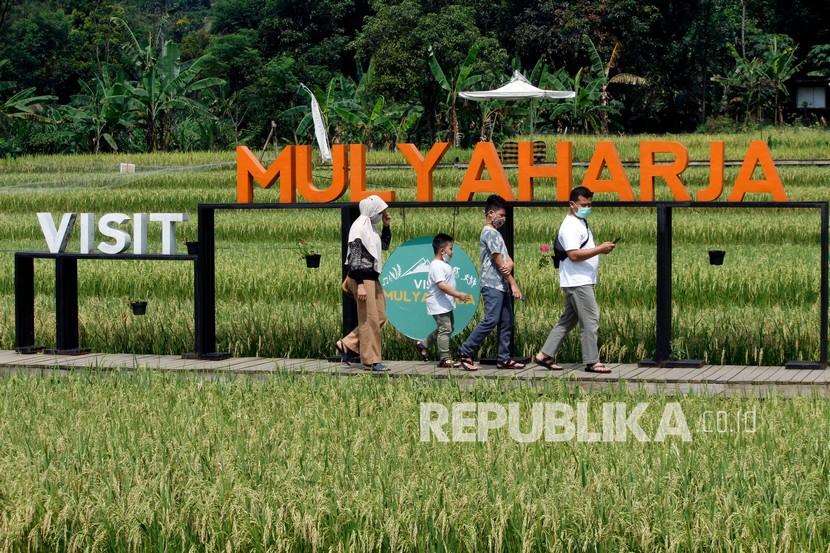 Pengunjung berjalan di lokasi wisata kampung tematik Ciharashas, Kelurahan Mulyaharja, Kota Bogor, Jawa Barat, Sabtu (26/6/2021). Perusahaan agen travel daring Tiket.com membuat program bertajuk 