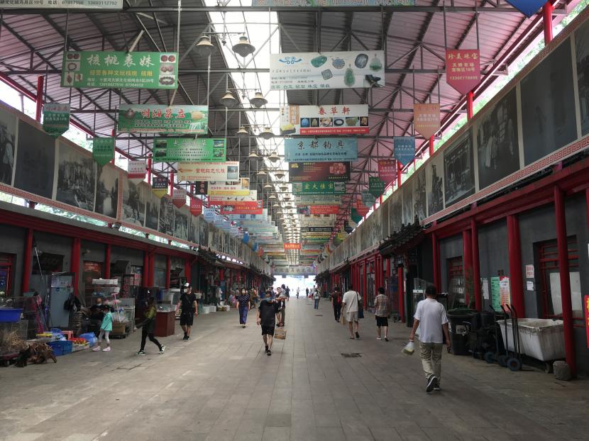 Pengunjung berjalan di lorong Pasar Shilihe yang dikenal sebagai pasar binatang piaraan dan barang-barang antik terbesar di Beijing, China, Sabtu (18/6/2022). Organisasi Kesehatan Dunia (WHO) menggelar komite darurat untuk mempertimbangkan wabah cacar monyet yang terus menyebar sebagai darurat global. 
