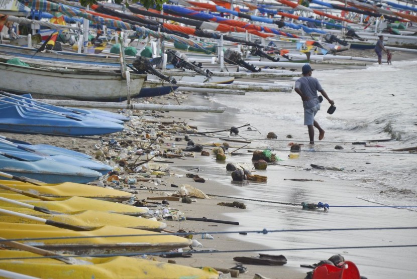 Pengunjung berjalan di pinggiran pantai Senggigi yang dipenuhi sampah di Desa Senggigi, Kecamatan Batulayar, Gerung, Lombok Barat, NTB