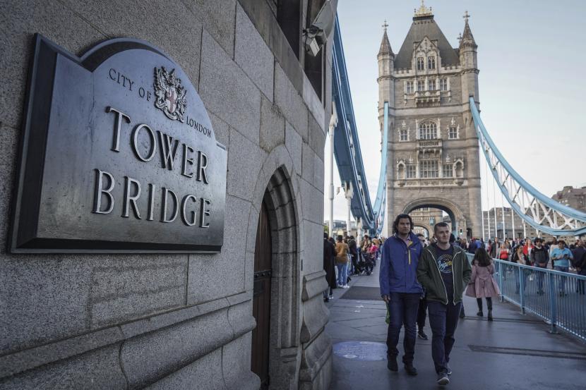 Pengunjung berjalan melintasi Tower Bridge di London, Inggris, Ahad (2/10/2022). Departemen Tenaga Kerja dan Pensiun Inggris mengatakan jutaan rumah tangga pendapatan rendah akan menerima bantuan langsung tunai dari pemerintah. 