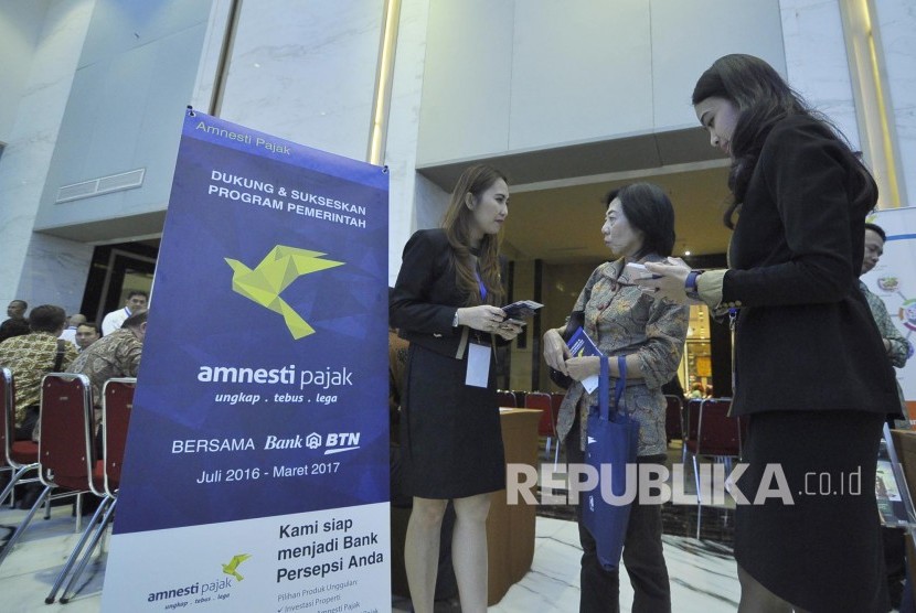 Pengunjung berkonsultasi dengan karyawati Bank BTN saat berlangsung acara Sosalisasi Kebijakan Amnesti Pajak oleh Presiden Republik Indonesia di Bandung, Senin (8/8). (mahmud Muhyidin)