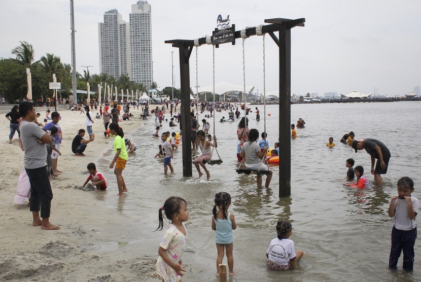Pengunjung bermain air di kawasan Pantai Karnaval Ancol. (ilustrasi)