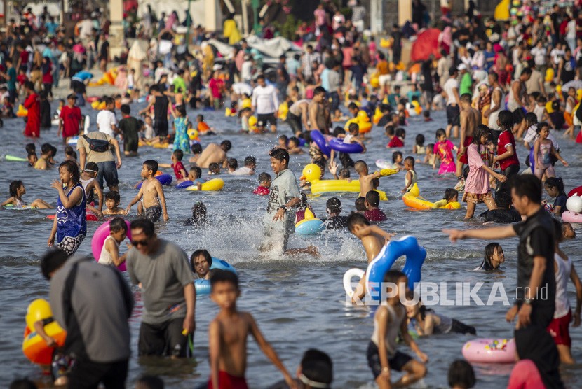 Pengunjung bermain air di Pantai Karnaval Ancol, Jakarta, Kamis (6/6/2019).