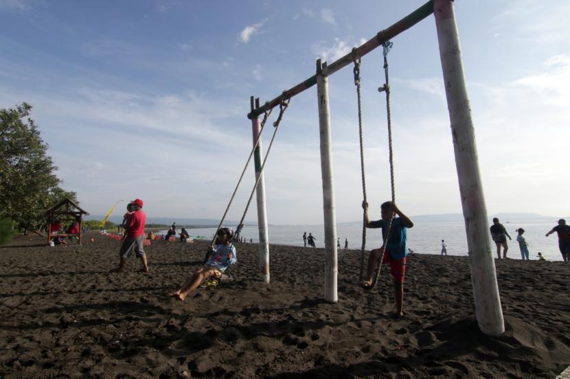 Pengunjung bermain ayunan di Pantai Pulau Santen, Banyuwangi, Jawa Timur, Sabtu (20/3). Menteri Pariwisata dan Ekonomi Kreatif, Sandiaga Salahuddin Uno mengimbau para pelaku pariwisata untuk tidak takut dan patah arang di tengah adanya aksi teror beberapa waktu lalu.