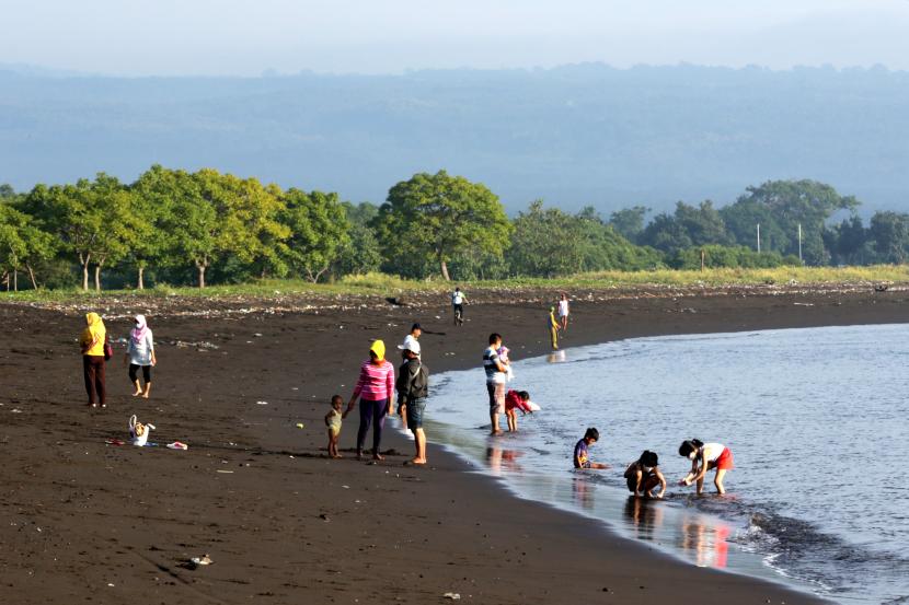 Pengunjung bermain di Pantai Pulau Santen, Banyuwangi, Jawa Timur. ilustrasi
