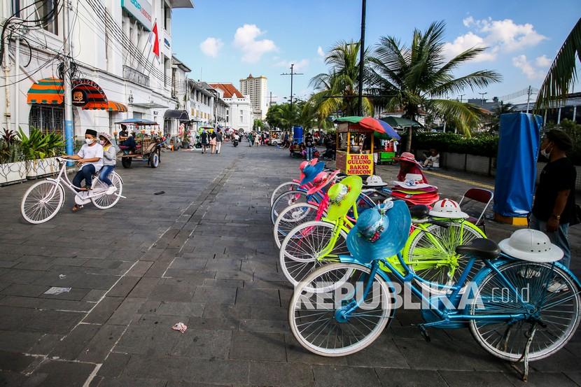 Pengunjung bermain sepeda di kawasan Kota Tua, Kecamatan Taman Sari, Jakarta Barat, Rabu (26/5/2021). 