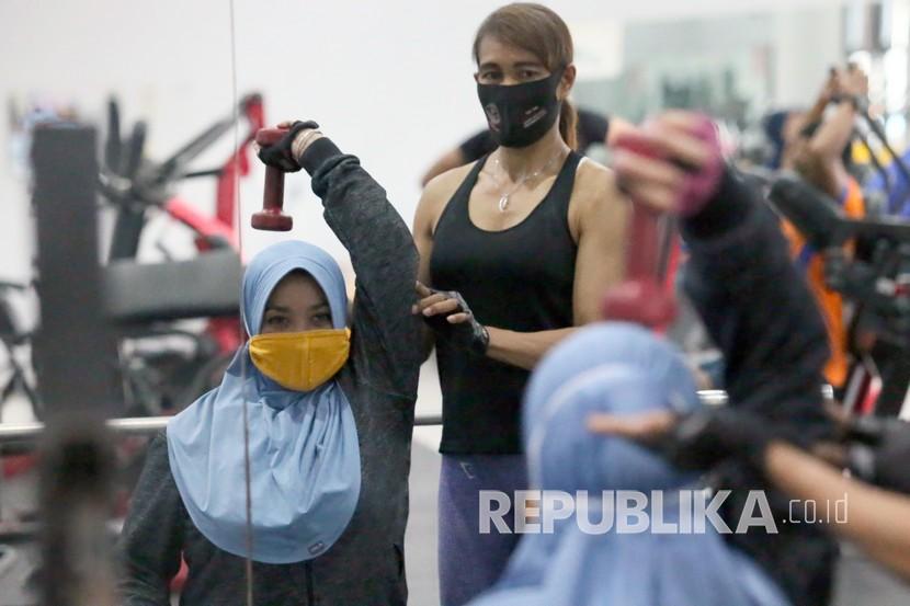 Pengunjung berolah raga angkat beban sambil menggunakan masker di salah satu pusat kebugaran di Kota Blitar, Jawa Timur. Melatih otot memiliki efek jangka panjang lebih dibandingkan sekadar kardio