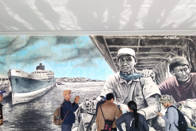 Pengunjung berpose mengabadikan mural 