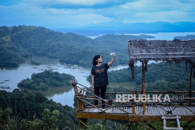 Pengunjung berswafoto dengan latar belakang Waduk Riam Kanan di wisata alam Bukit Matang Kaladan, Banjar, Kalimantan Selatan, Ahad (14/4/2019).