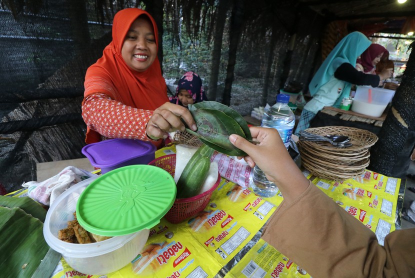 Pengunjung bertransaksi menggunakan daun di kawasan Peken Godong (pasar daun) di Desa Kawedusan, Kediri, Jawa Timur, Ahad (12/5/2019).