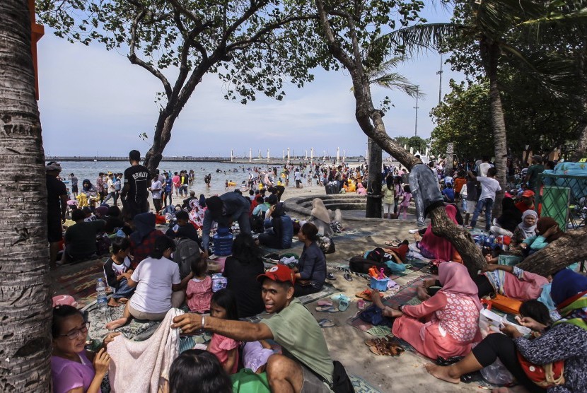 Pengunjung dari berbagai daerah memadati Pantai Festival Taman Impian Jaya Ancol, Jakarta, Senin (26/12). 