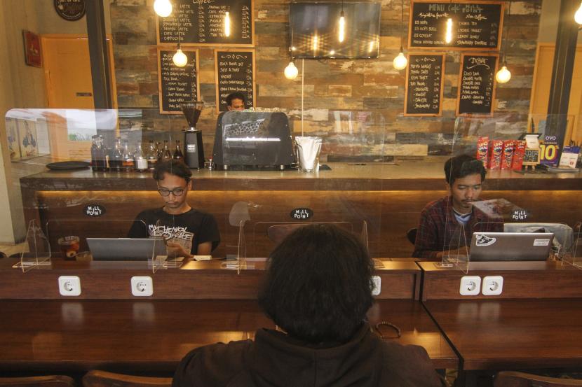 Pengunjung dengan sekat plastik duduk berjaga jarak di kedai kopi Mill Point, Depok, Jawa Barat, Selasa (9/6). Badan Keuangan Daerah (BKD) Kota Depok akan memangkas pajak restoran sebesar tiga persen. 