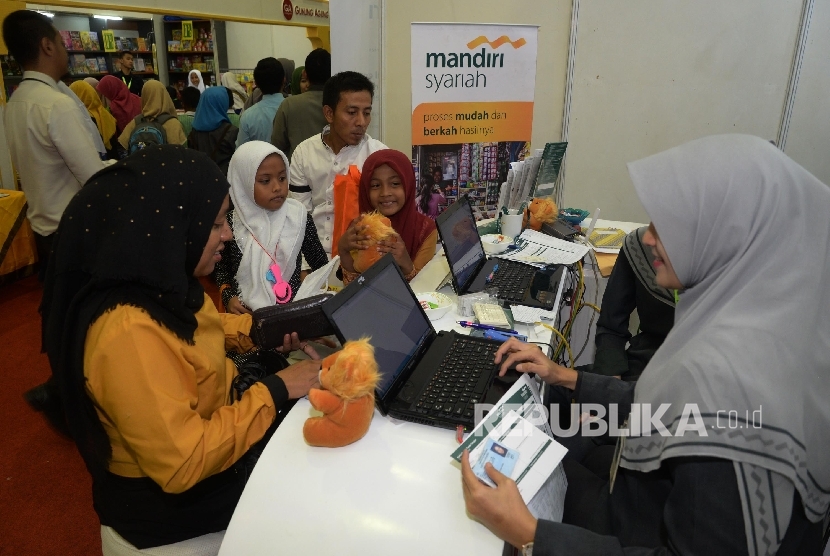 Pengunjung Islamic Book Fair (IBF) 2017 tengah mengisi aplikasi pembukaan rekening di booth Bank Syariah Mandiri (BSM) di IBF JCC Senayan, Jakarta, Kamis (4/5). 