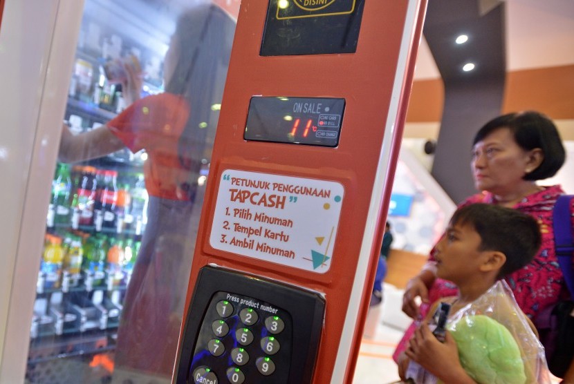 Pengunjung melakukan transaksi di mesin minuman otomatis menggunakan uang elektronik ketika Pameran Indonesia Business and Development 2017 di JCC Senayan, Jakarta, Kamis (21/9).