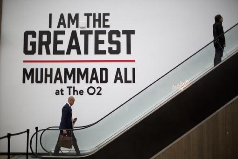 Pengunjung melewati kutipan besar Muhammad Ali dekat eskalator pintu masuk pameran di arena O2, Sabtu, 4 Juni 2016. O2 menjadi tempat pertarungan tinju bergengsi di London, Inggris..