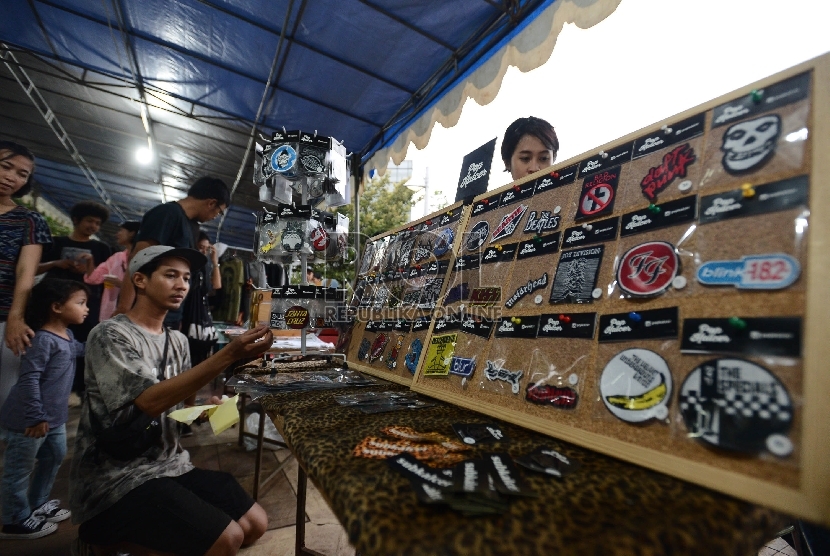 Pengunjung melihat-lihat cinderamata yang dijual saat Konser Perubahan Iklim yang diadakan di Taman Menteng, Jakarta, Ahad (6/12). (Republika/Raisan Al Farisi)