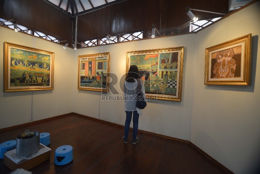 Pengunjung melihat-lihat lukisan betawi di Pendopo Batik, Museum Tekstil, Jakarta barat, Ahad, (7/12). Selain pameran lukisan yang dilukis oleh Sarnadi Adam dengan tema 